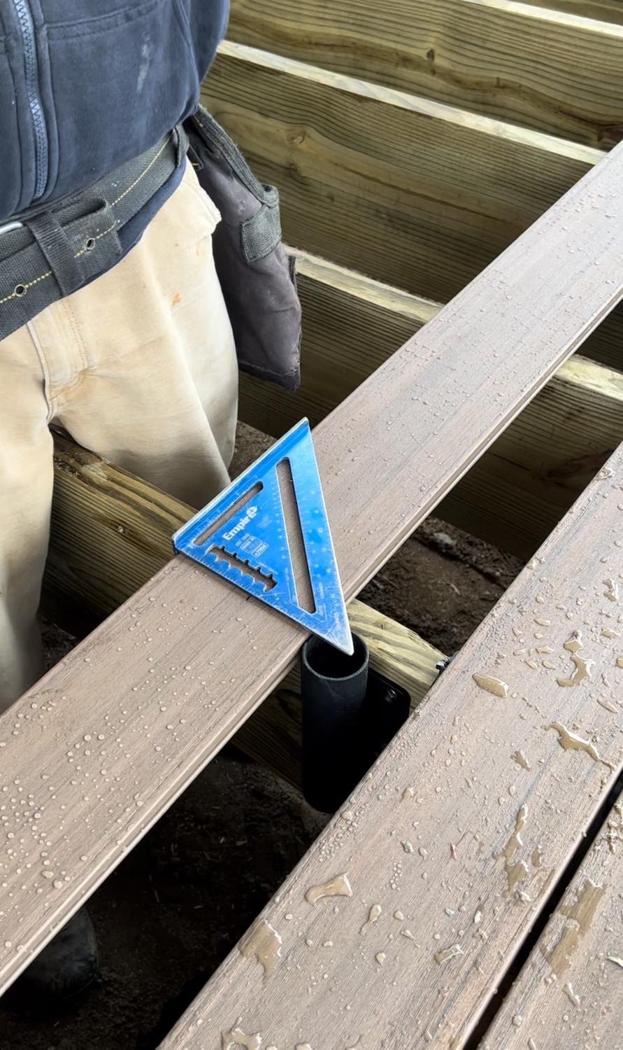 Deck builder fitting a Patio Buddy sleeve under deck boards