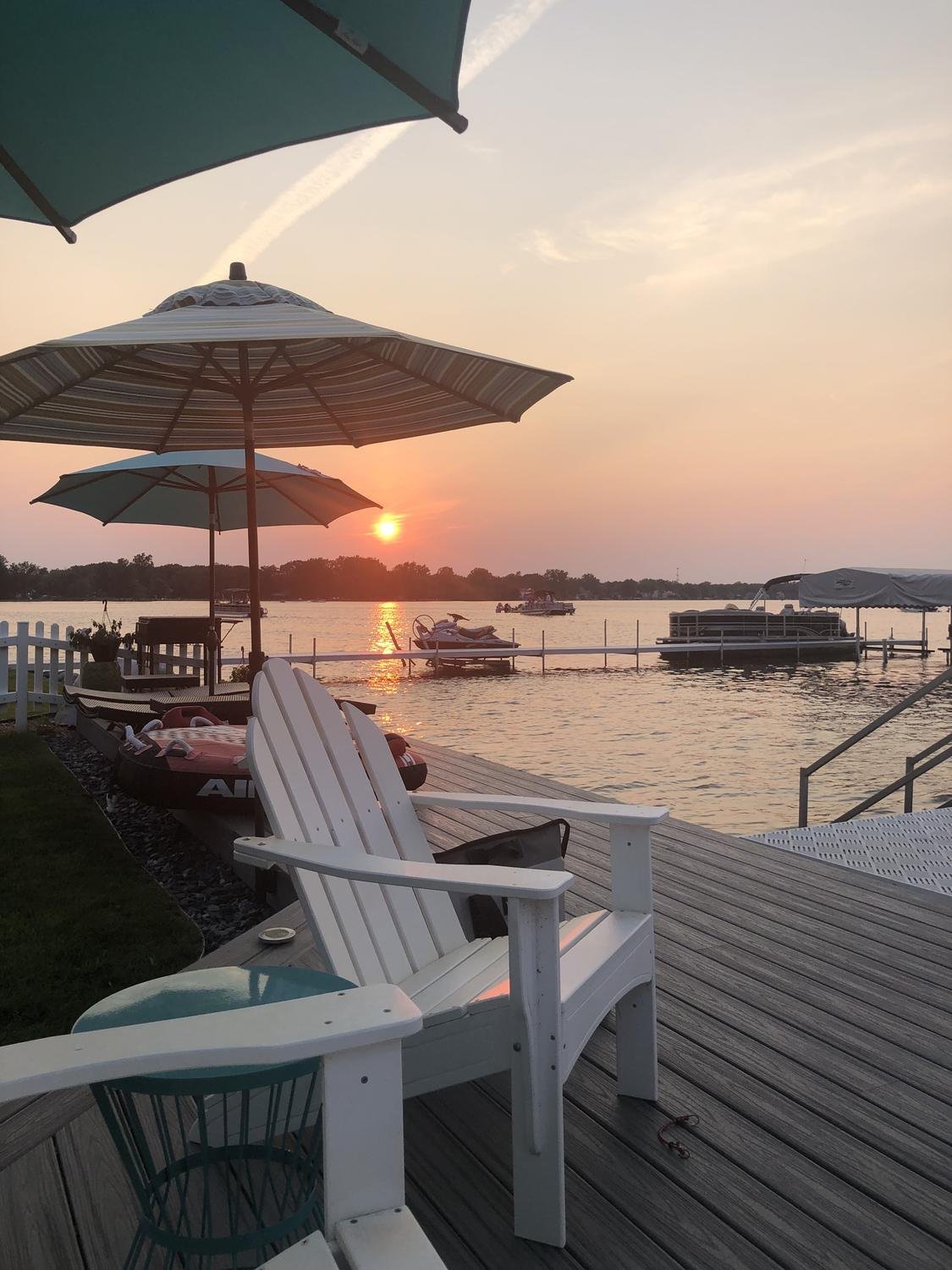 Umbrellas mounted with Patio Buddy on a lakefront deck at sunset