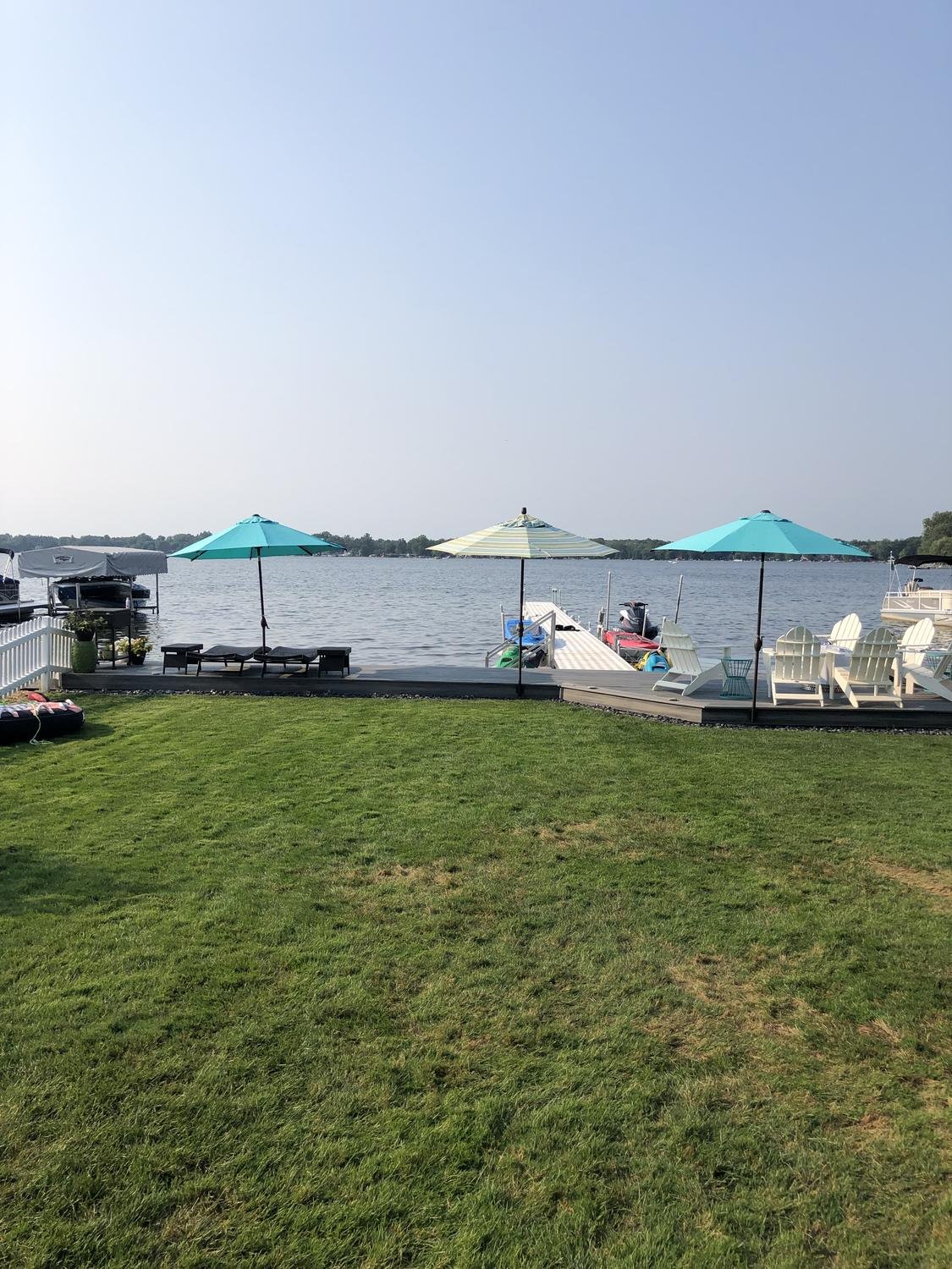 Three umbrellas mounted along a lakefront deck