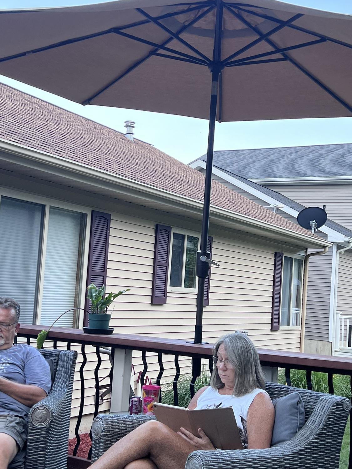 Couple relaxing on a deck under a mounted umbrella