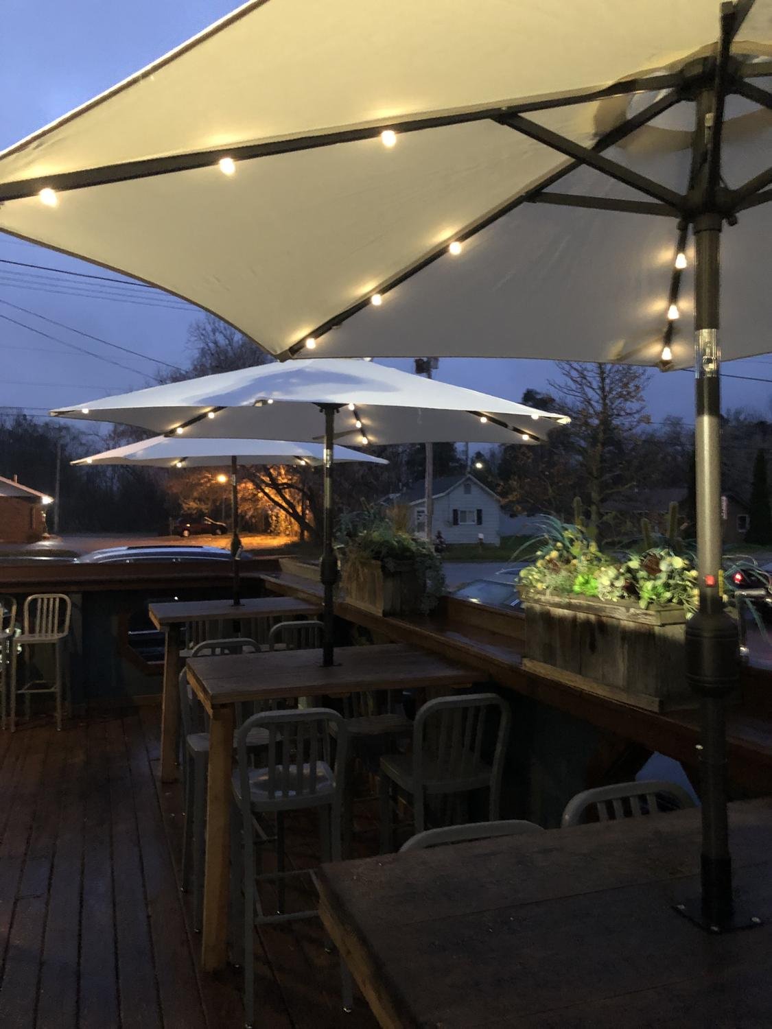 Restaurant patio umbrellas with lights at dusk