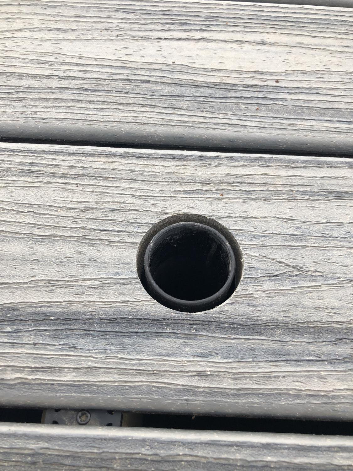 Embedded sleeve flush with composite decking