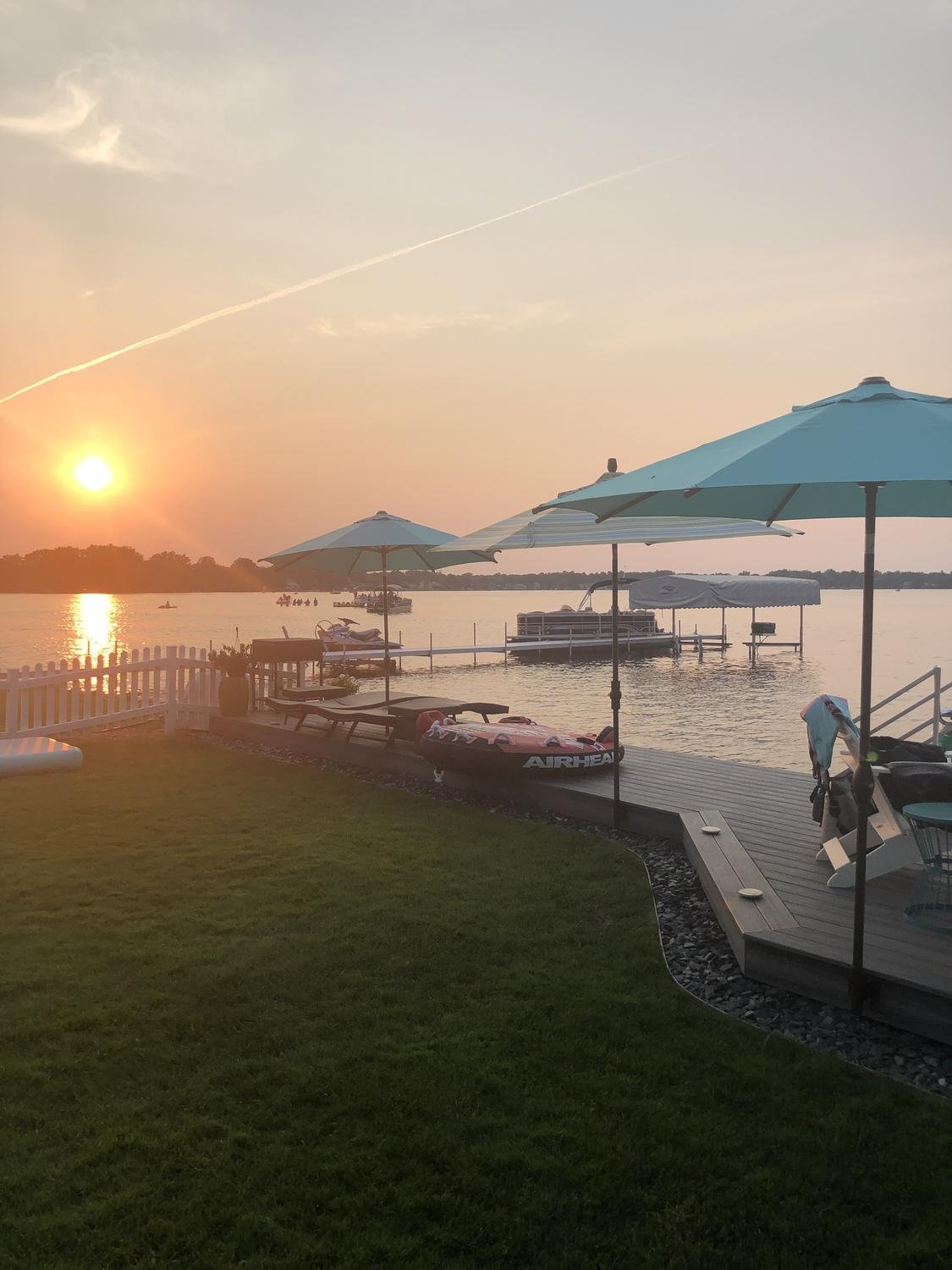 Lakefront deck with umbrellas at sunset